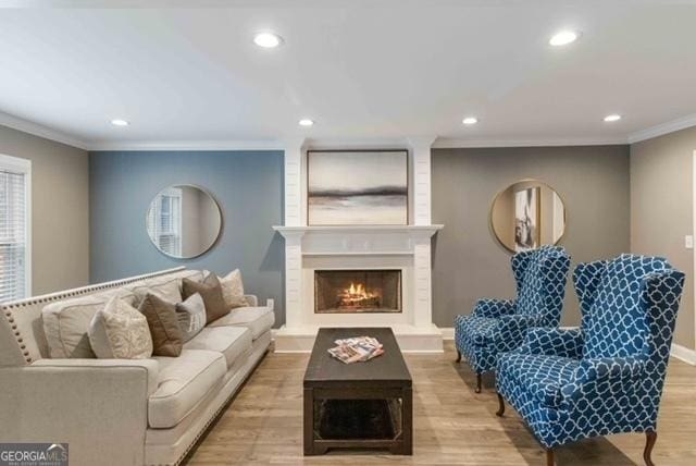 living room featuring ornamental molding, a fireplace, wood finished floors, and recessed lighting