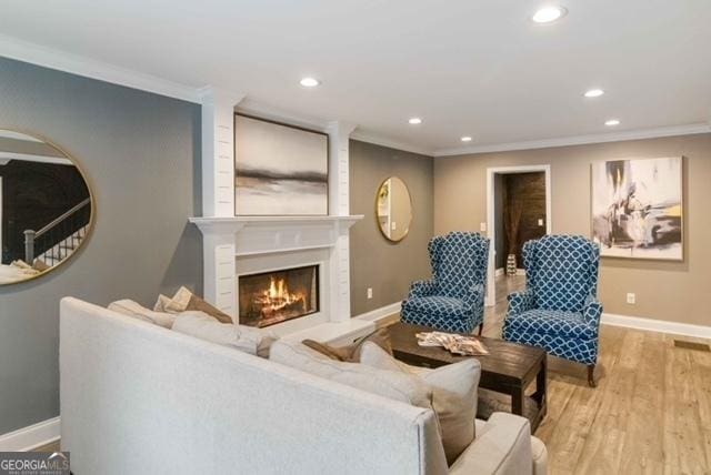 living room featuring recessed lighting, crown molding, and wood finished floors