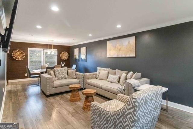 living area featuring baseboards, ornamental molding, wood finished floors, and recessed lighting