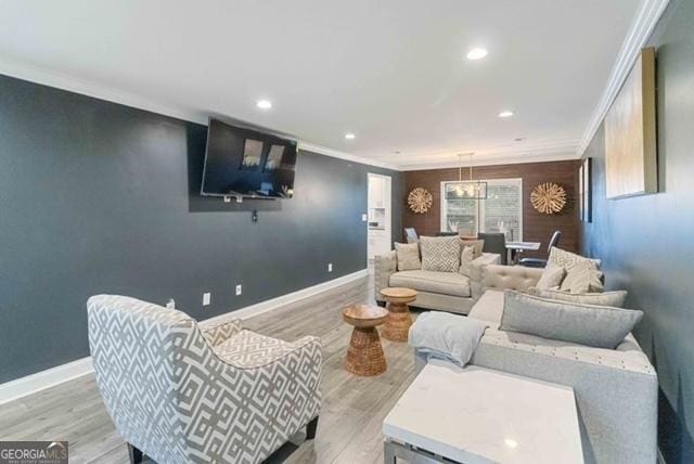 living area featuring baseboards, wood finished floors, and crown molding