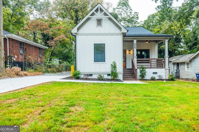 view of front of property featuring board and batten siding, crawl space, a porch, and a front lawn