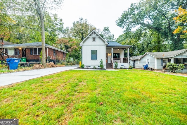 view of front of house featuring covered porch, crawl space, a front yard, and board and batten siding