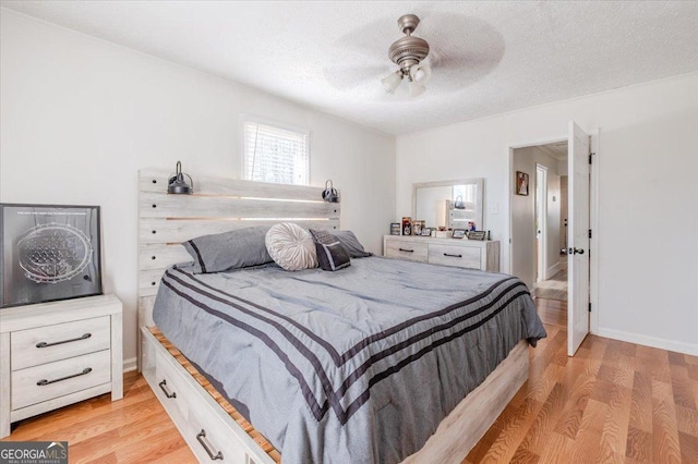 bedroom featuring light wood-type flooring, ceiling fan, baseboards, and a textured ceiling