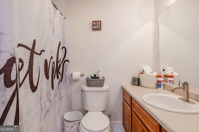 bathroom featuring a shower with shower curtain, vanity, and toilet