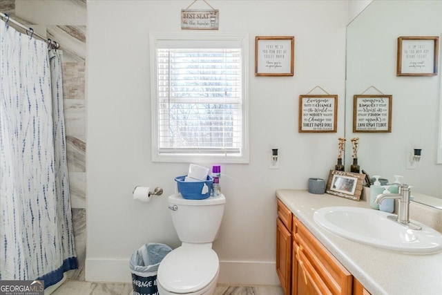 bathroom featuring toilet, vanity, and a healthy amount of sunlight