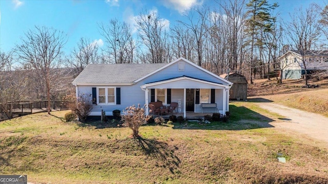 view of front of property featuring driveway, covered porch, and a front lawn