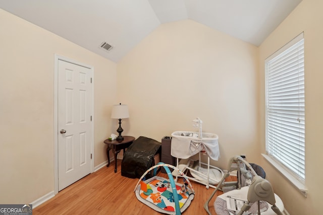 rec room with visible vents, baseboards, wood finished floors, and vaulted ceiling