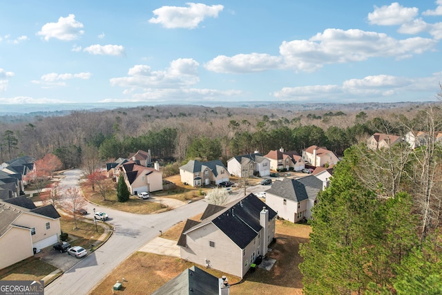bird's eye view featuring a wooded view and a residential view