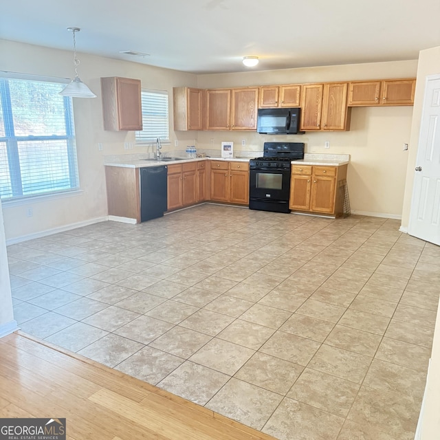 kitchen with visible vents, black appliances, a sink, light countertops, and baseboards