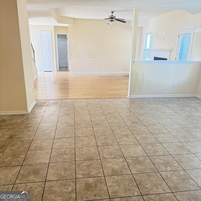 spare room featuring light tile patterned floors, baseboards, and a ceiling fan