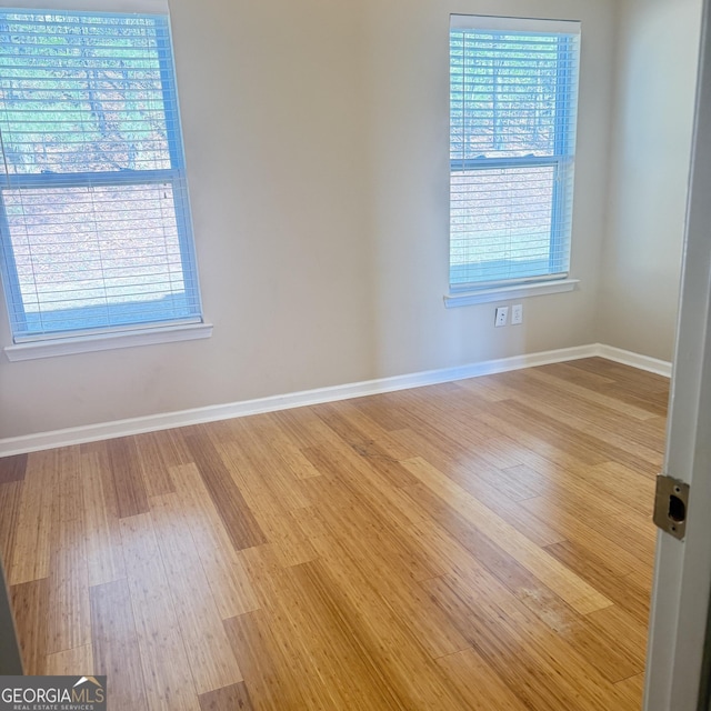 spare room with light wood-style flooring and baseboards