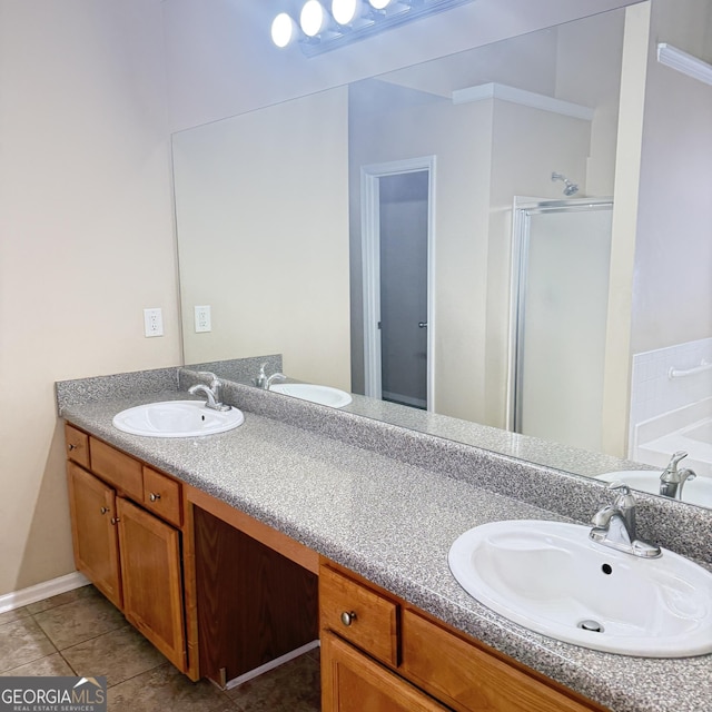 bathroom featuring a shower stall, double vanity, and a sink