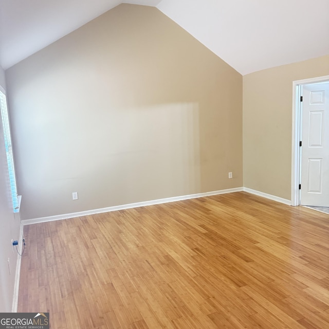 bonus room with light wood-type flooring, baseboards, and vaulted ceiling