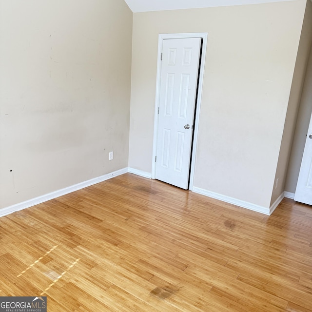 empty room with light wood finished floors and baseboards