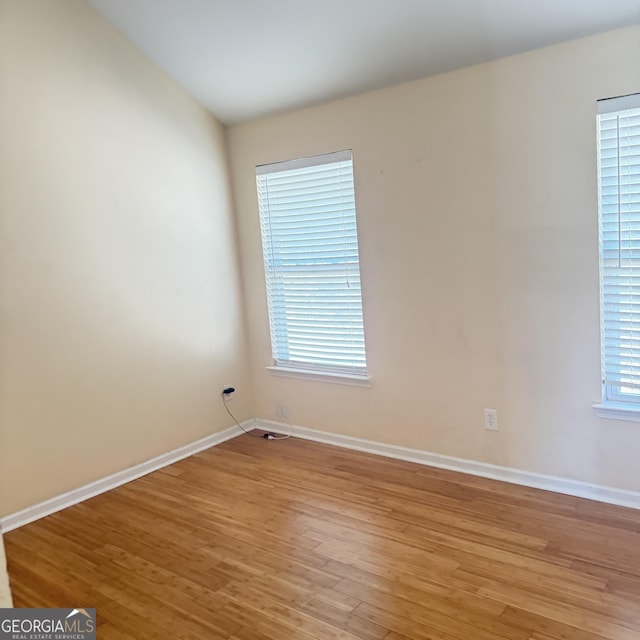 empty room featuring light wood finished floors and baseboards