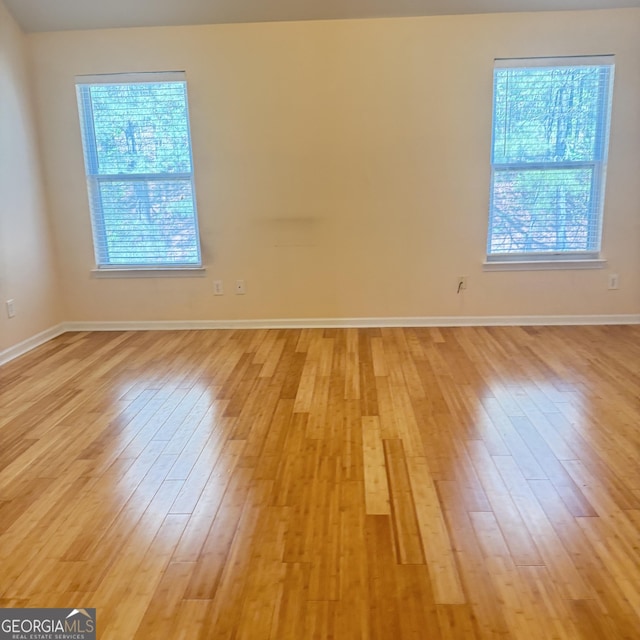 empty room featuring light wood finished floors and baseboards