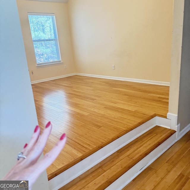 empty room with wood finished floors and baseboards