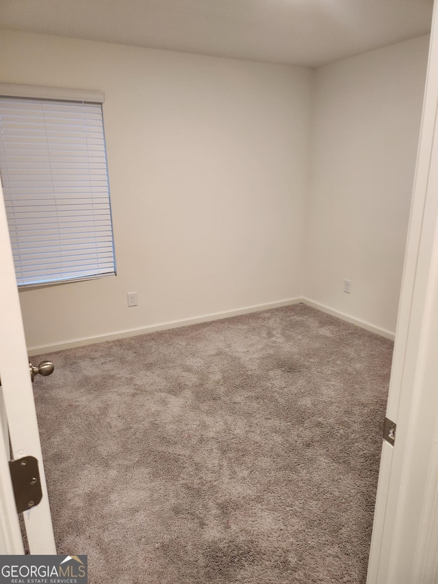 carpeted empty room with baseboards