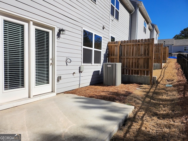 view of side of home with central air condition unit, a patio area, and fence