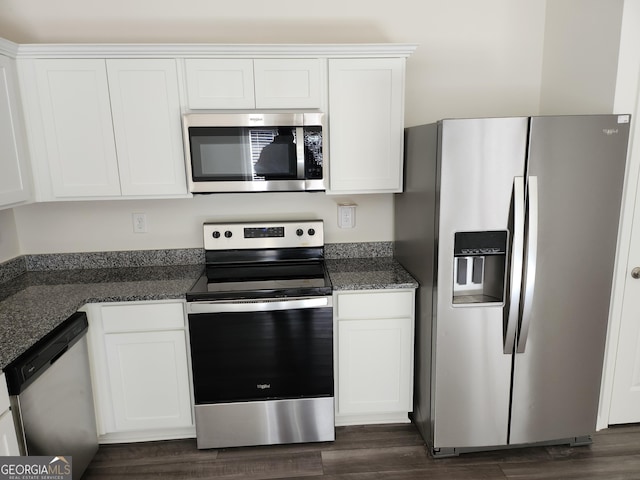 kitchen featuring white cabinetry, appliances with stainless steel finishes, dark stone counters, and dark wood-style flooring