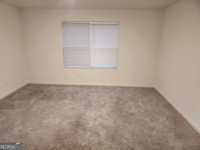 empty room featuring carpet floors and baseboards