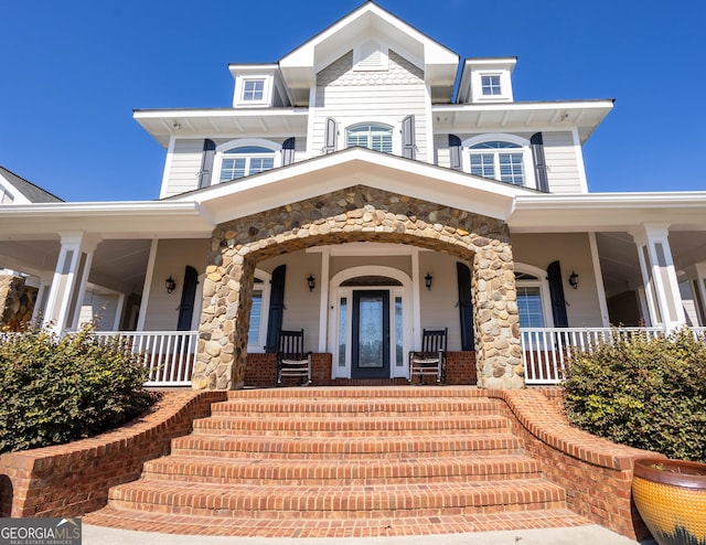 view of front facade with a balcony and covered porch