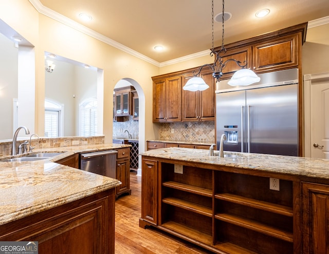 kitchen with a sink, ornamental molding, appliances with stainless steel finishes, light stone countertops, and open shelves