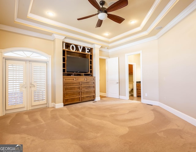 unfurnished living room with carpet floors, a raised ceiling, ornamental molding, and baseboards