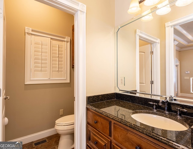 bathroom with toilet, visible vents, vanity, and baseboards