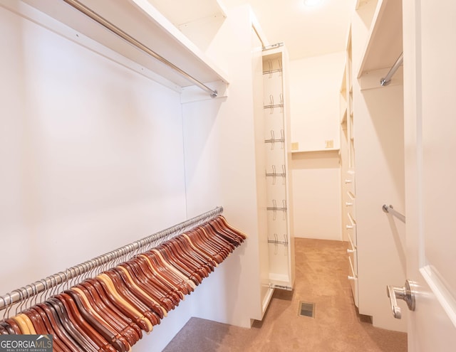 walk in closet featuring light carpet and visible vents