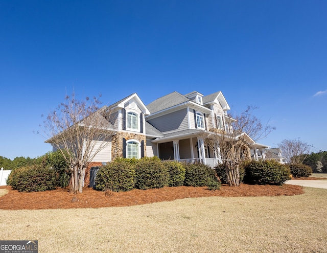 view of side of home featuring covered porch