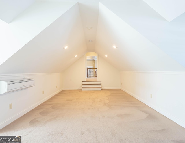 additional living space with an AC wall unit, light carpet, vaulted ceiling, and baseboards