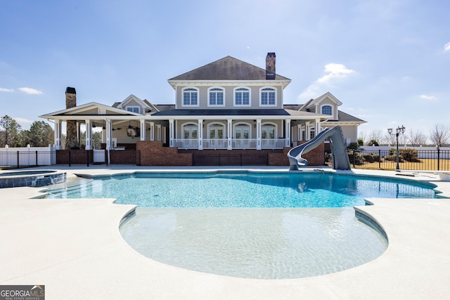 view of pool featuring a water slide, fence, and a patio