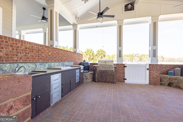 view of patio / terrace with exterior kitchen, a ceiling fan, and area for grilling