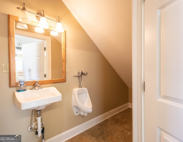 bathroom with lofted ceiling, tile patterned flooring, a sink, and baseboards