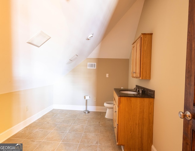 bathroom featuring visible vents, toilet, vaulted ceiling, baseboards, and tile patterned floors