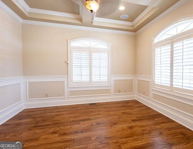 spare room featuring visible vents, a wainscoted wall, ornamental molding, wood finished floors, and a decorative wall