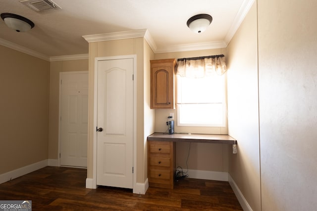 unfurnished office featuring baseboards, visible vents, dark wood-type flooring, and ornamental molding