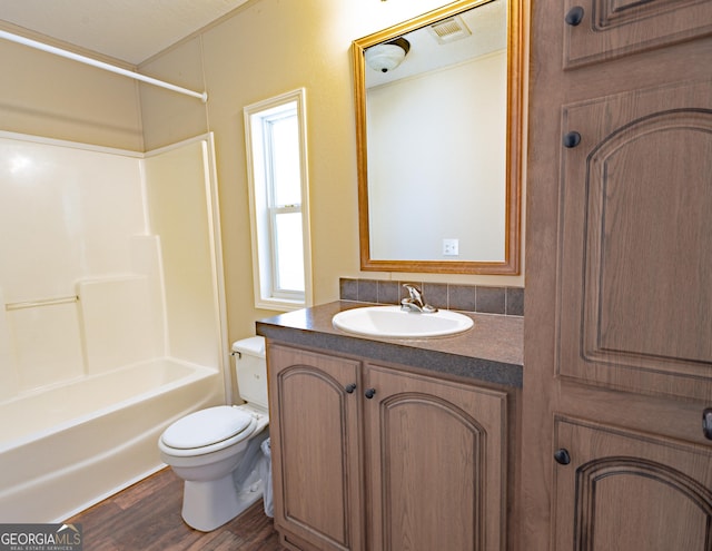 bathroom with bathtub / shower combination, toilet, wood finished floors, visible vents, and vanity