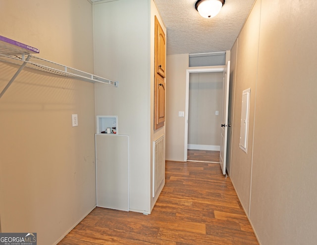 hall featuring a textured ceiling and dark wood-type flooring