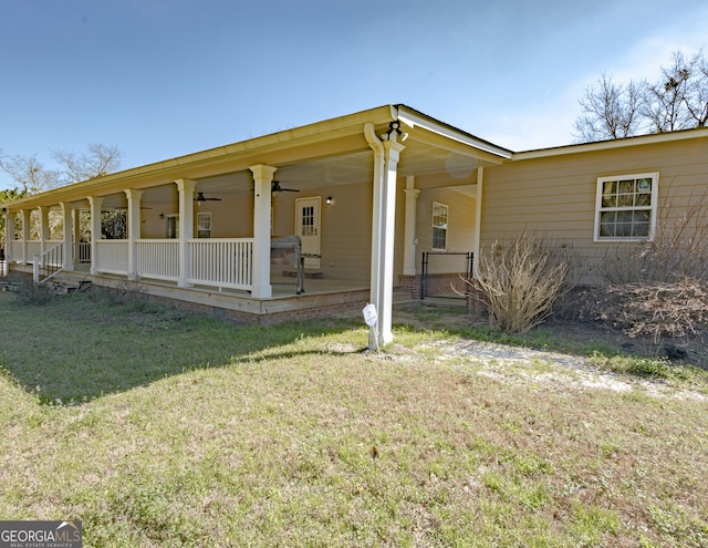 view of front of home with a ceiling fan and a front lawn