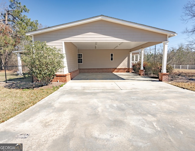 view of front facade featuring driveway, a carport, and fence