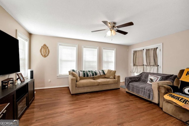 living room with baseboards, a ceiling fan, and wood finished floors