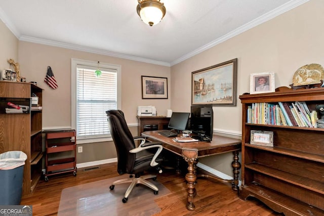 office featuring visible vents, crown molding, baseboards, and wood finished floors