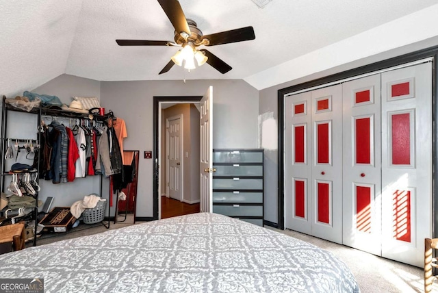 bedroom featuring carpet floors, a closet, vaulted ceiling, a textured ceiling, and ceiling fan