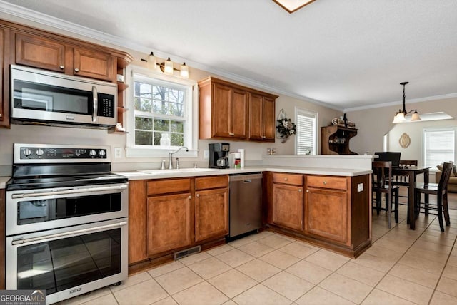 kitchen with stainless steel appliances, a peninsula, a sink, visible vents, and a wealth of natural light