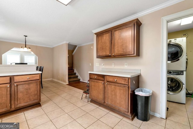 kitchen with stacked washing maching and dryer, brown cabinets, and light countertops