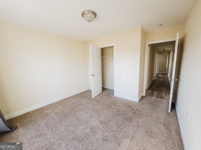 unfurnished bedroom with carpet floors, a closet, and baseboards