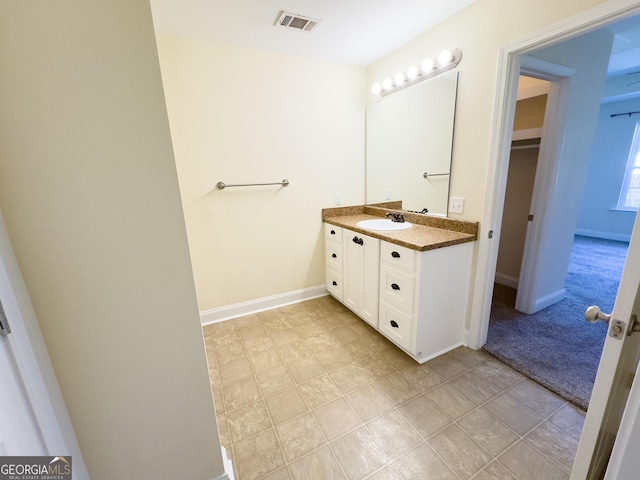 bathroom with baseboards, visible vents, and vanity