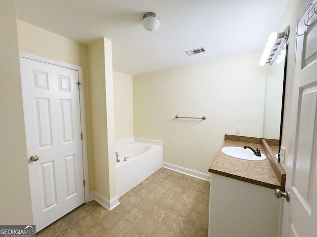 bathroom featuring visible vents, vanity, baseboards, and a bath